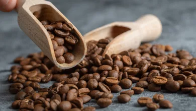 Wooden Scoop Filled with Roasted Coffee Beans Spilling Onto a Textured Gray Surface El Espacio Donde El Café Y El Chocolate Cuentan Su Historia Zaragozala Qué Hacer En Zaragoza