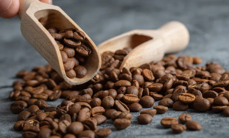 Wooden Scoop Filled with Roasted Coffee Beans Spilling Onto a Textured Gray Surface El Espacio Donde El Café Y El Chocolate Cuentan Su Historia Zaragozala   Qué Hacer En Zaragoza