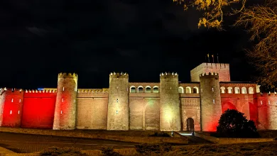 Night View of a Medieval Fortress with Tall Cylindrical Towers Illuminated Red and Amber Along the Wall at Night La Aljafería Se Ilumina Por La Final España argentina Zaragozala Qué Hacer En Zaragoza