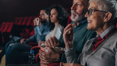 Smiling Elderly Woman with Short White Hair and Glasses Eats Popcorn in a Movie Theater Seated with Others in Red Seats Zaragozala | Agenda Cultural Ocio Y Planes En Zaragoza Zaragozala   Qué Hacer En Zaragoza