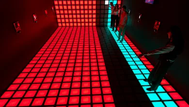 People Standing on a Glowing Grid of Red Led Floor Tiles with a Turquoise Strip Along the Right Edge in a Dark Room Dónde Jugar a El Suelo Es Lava En Zaragoza Zaragozala Qué Hacer En Zaragoza