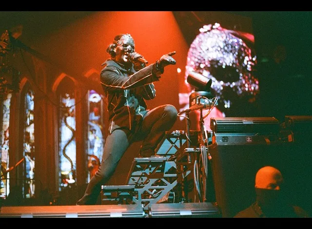 Masked Performer on a Multi level Stage Under Orange Lighting Pointing to the Crowd with a Skull Projection in the Background 2 Big to Rig De Ghost En Zaragoza En Formato Imax Zaragozala Qué Hacer En Zaragoza