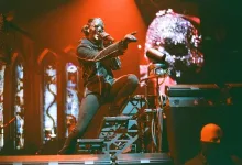 Masked Performer on a Multi level Stage Under Orange Lighting Pointing to the Crowd with a Skull Projection in the Background Zaragozala | Agenda Cultural Ocio Y Planes En Zaragoza Zaragozala Qué Hacer En Zaragoza