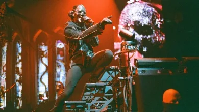 Masked Performer on a Multi level Stage Under Orange Lighting Pointing to the Crowd with a Skull Projection in the Background Zaragozala | Agenda Cultural Ocio Y Planes En Zaragoza Zaragozala   Qué Hacer En Zaragoza