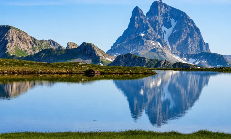 Snow capped Mountain Reflected in a Calm Alpine Lake with Green Meadow in Foreground Ibones De Anayet Multas Por Acampar Y Bañarse Zaragozala Qué Hacer En Zaragoza