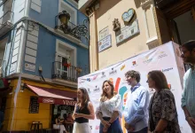 Group of People Walking Along a Sunlit City Street During a Festival Blue Building on the Left and Sponsor Banner in the Foreground Zaragoza Pide Declarar El Tubo Bien De Interés Turístico Zaragozala   Qué Hacer En Zaragoza