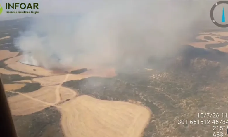 Aerial View of a Wildfire with Smoke Rising over Beige Fields and Winding Dirt Roads Seen from a Helicopter Infoar Logo in Corner Incendio De Orés Evacuados 3 Pueblos Y Activado El Nivel 2 Zaragozala   Qué Hacer En Zaragoza