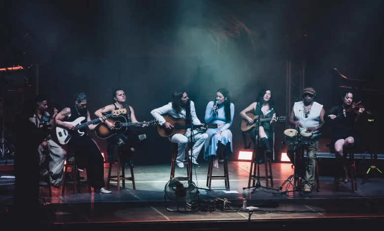 Group of Diverse Musicians on a Dimly Lit Stage Playing Guitars and Singing into Microphones During a Live Concert Valeria Castro Y Carlos Ares Llenan En Pirineos Sur 2026 Zaragozala   Qué Hacer En Zaragoza