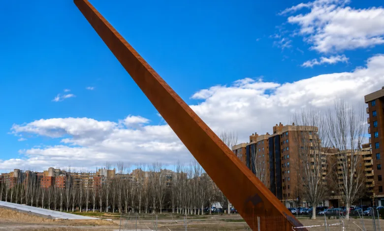 Rusty Diagonally Leaning Metal Sculpture in a City Park with Leafless Trees and Apartment Buildings in the Background Zaragozala | Agenda Cultural Ocio Y Planes En Zaragoza Zaragozala   Qué Hacer En Zaragoza
