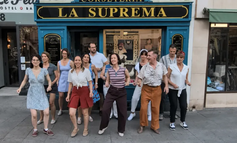 Group of Ten Adults Dancing in Front of a Bright Blue Storefront Labeled La Suprema Corseteria on a City Street in Summer Attire El Swing Se Cuela En El Comercio Local De Zaragoza Zaragozala Qué Hacer En Zaragoza