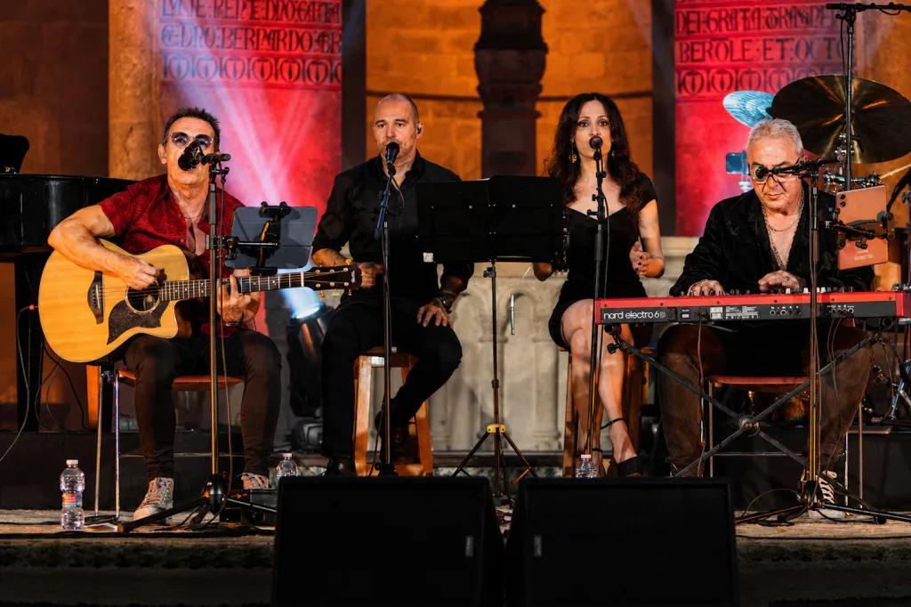 Four member Band Performing on a Lit Stage Guitarist on Left Two Singers Center and a Keyboardist on the Right with a Red Nord Keyboard Tako Repasa Cuatro Décadas De Historia En Un Veruela Lleno Zaragozala Qué Hacer En Zaragoza