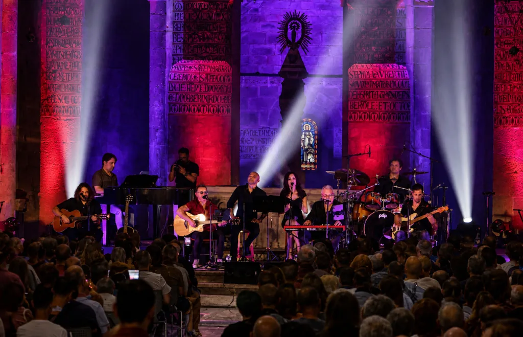 a Live Band Performs on a Lit Stage Inside a Church with Multiple Musicians Playing Guitars Keyboard Drums and a Singer While a Large Audience Watches Tako Repasa Cuatro Décadas De Historia En Un Veruela Lleno Zaragozala Qué Hacer En Zaragoza