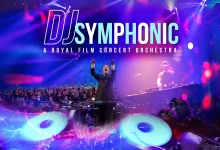 Conductor Raises Arms on a Stage with a Full Orchestra and a Dj Deck Under Neon Purple and Blue Lights with a dj Symphonic Banner Above Zaragozala | Agenda Cultural Ocio Y Planes En Zaragoza Zaragozala   Qué Hacer En Zaragoza