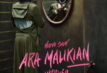 Man in a Green Coat Adjusts His Tie While Facing an Ornate Wall Mirror a Violin Rests on the Floor Beside a Bold Pink Poster That Reads art Malikian Intruso Zaragozala | Agenda Cultural Ocio Y Planes En Zaragoza   Página 109 Zaragozala   Qué Hacer En Zaragoza