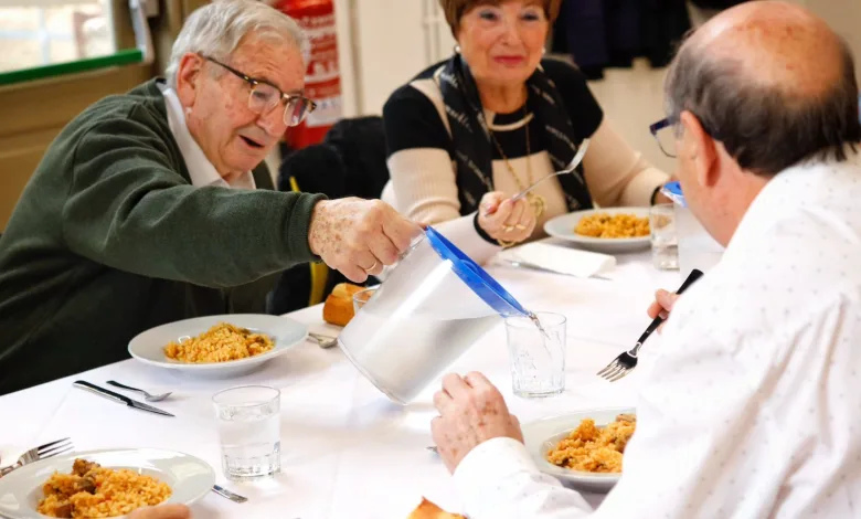 Elderly Man Pours Water from a Pitcher into a Glass at a Communal Meal As Others Watch and Eat from Plates of Risotto or Pasta Más Plazas De Comedor Para Los Mayores De Zaragoza En Agosto Zaragozala Qué Hacer En Zaragoza