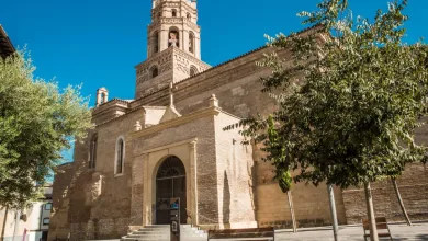 Stone Church with Arched Entrance and Tall Bell Tower Set in a Sunny Plaza with Trees Nearby Conciertos De Espacio Catedral En Monzón 2026 Zaragozala Qué Hacer En Zaragoza