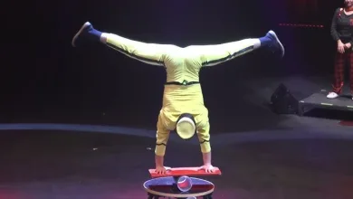 Acrobat in Yellow Performs a Handstand with Legs Extended in a Split Atop a Red Platform on a Dark Stage Festival Pista Central 2026 Circo Gratis Cerca De Zaragoza Zaragozala Qué Hacer En Zaragoza