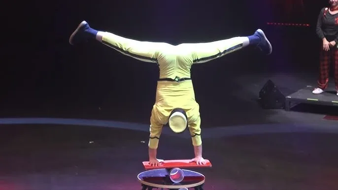 Acrobat in Yellow Performs a Handstand with Legs Extended in a Split Atop a Red Platform on a Dark Stage Festival Pista Central 2026 Circo Gratis Cerca De Zaragoza Zaragozala Qué Hacer En Zaragoza