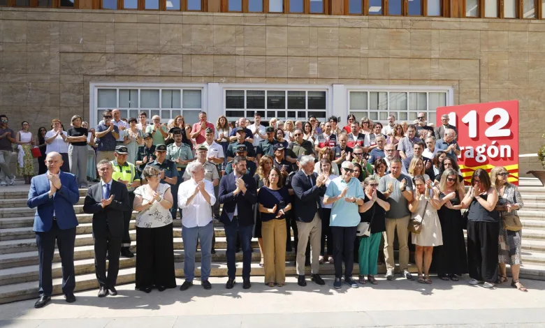 Large Diverse Group Standing on Steps Outside a Stone Building Clapping with a Red 12 Aragón Banner Visible Luto Oficial En Aragón Por El Soldado De La Ume Zaragozala Qué Hacer En Zaragoza