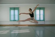 Ballet Dancer in a Black Leotard and Light Shorts Mid leap in a Bright Studio with Teal Curtains Behind Her Zaragozala | Agenda Cultural Ocio Y Planes En Zaragoza Zaragozala Qué Hacer En Zaragoza