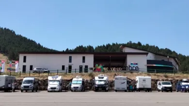 Row of Motorhomes and Caravans Parked in Front of a Modern Building on a Hillside Under a Clear Blue Sky Visitantes De 82 Países Llegan a Aragón Por El Eclipse Zaragozala Qué Hacer En Zaragoza