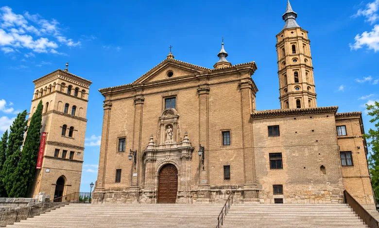 Brick Church with Two Towers and Grand Stairway Against a Bright Blue Sky Historic Architectural Facade La Torre Inclinada De Zaragoza San Juan De Los Panetes Zaragozala   Qué Hacer En Zaragoza