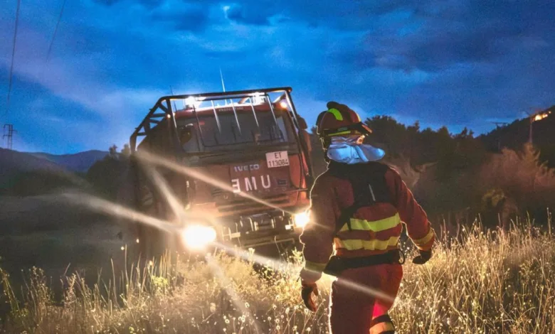 Firefighter in Reflective Gear and Helmet Stands in Tall Grass As a Tilted Fire Truck Glows with Headlights at Nightfall Muere Un Militar De La Ume Durante La Extinción Del Incendio De Las Peñas De Riglos Zaragozala   Qué Hacer En Zaragoza