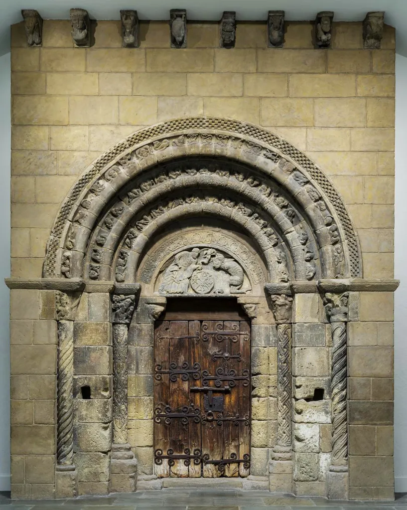 Stone Arch Doorway with Multiple Decorative Concentric Arches and a Weathered Wooden Door with Wrought iron Hinges and Hinges La Portada De San Miguel De Uncastillo Que Acabó En Boston Zaragozala   Qué Hacer En Zaragoza