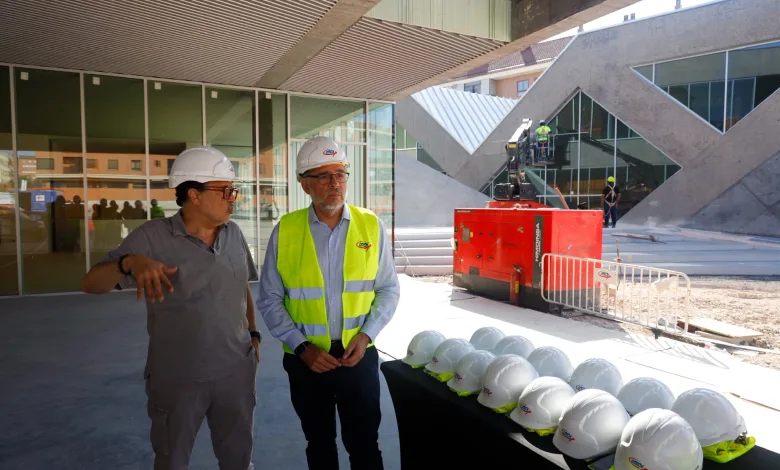 Two Construction Workers Wearing White Hard Hats and a High visibility Vest Stand Near a Row of Safety Helmets at a Building Construction Site El Centro Cívico Hispanidad Encara Su Recta Final Abrirá a Principios De 2027 Zaragozala Qué Hacer En Zaragoza