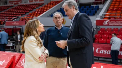 Three Adults in a Conversation in a Sports Arena with Red Seating and Banners in the Background the Woman Wears a Cream Blazer the Man in the Middle Wears a Blue Sweater and the Tall Man on the Right Wears a Dark Suit the Setting Appears to Be a Gym or Stadium Concourse Pepe Arcega Zaragoza Retira Su Dorsal 10 Esta Noche Zaragozala   Qué Hacer En Zaragoza