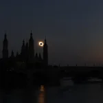 Silhouetted City Skyline with Tall Church Spires at Dusk a Solar Eclipse Visible Near the Horizon over the Buildings and a Reflection on the Water Below Miles De Personas Observan El Eclipse Total En Zaragoza Zaragozala Qué Hacer En Zaragoza