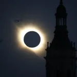 Solar Eclipse Halo Behind a Dark Circular Disk with a Silhouetted Clock Tower to the Right and a Bird in Flight Nearby Miles De Personas Observan El Eclipse Total En Zaragoza Zaragozala Qué Hacer En Zaragoza