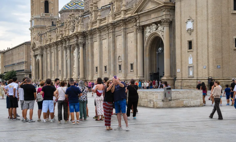 Crowd of Tourists in Front of a Grand Stone Cathedral with Ornate Arches and Statues Along Its Facade on a Wide Plaza El Puente De Agosto Llena Zaragoza De Turistas Zaragozala   Qué Hacer En Zaragoza